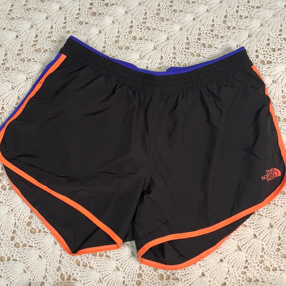 Black North Face running shorts with orange and blue accents